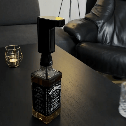 Hand using TipsyTap dispenser to pour whiskey into a glass